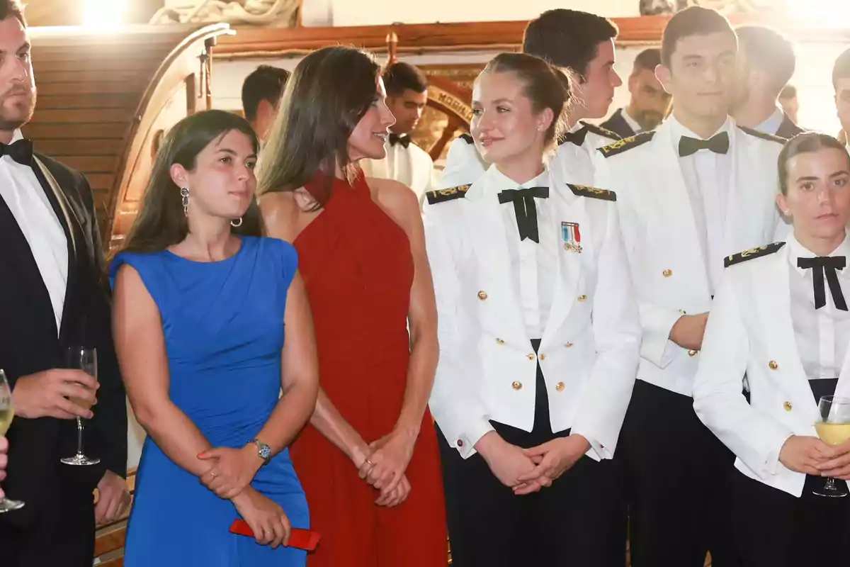 Queen Letizia and Princess Leonor dressed formally, some in white uniforms and others in evening gowns, at a social event. Queen Letizia and Princess Leonor dressed formally, some in white uniforms and others in evening gowns, at a social event.