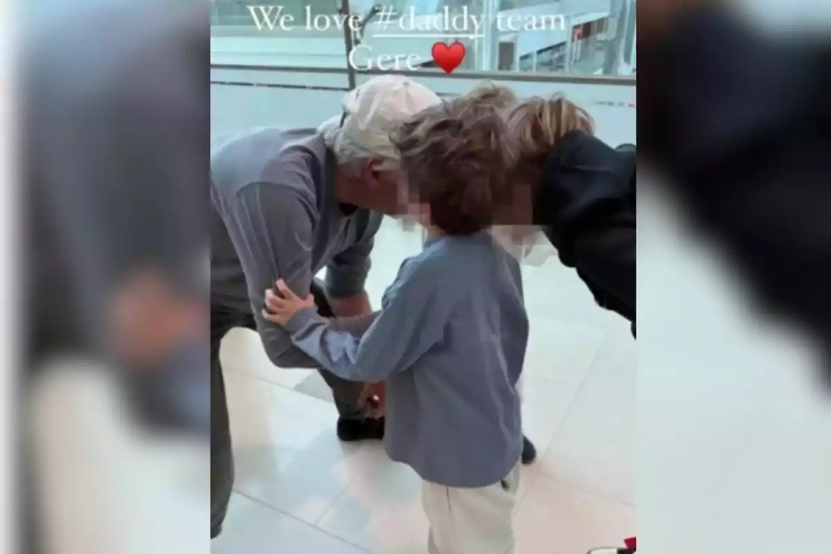 A man in a white cap leans down to hug a child in a well-lit indoor space. A man in a white cap leans down to hug a child in a well-lit indoor space.
