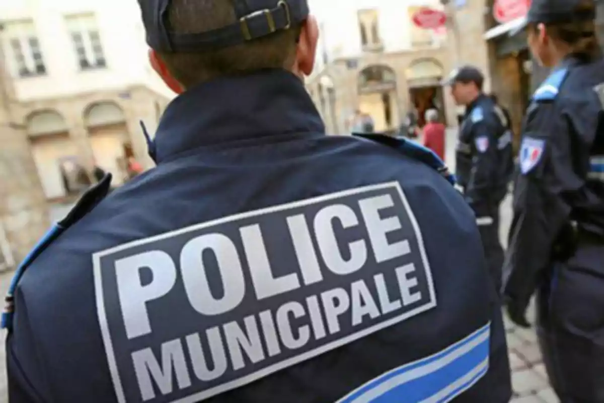 Un grupo de agentes de la policía municipal en uniforme patrullando una calle.