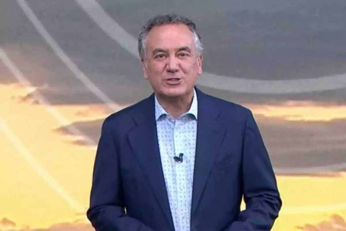 Plano medio de Roberto Brasero de pie con traje oscuro y camisa clara frente a un fondo con tonos cálidos. Plano medio de Roberto Brasero de pie con traje oscuro y camisa clara frente a un fondo con tonos cálidos.