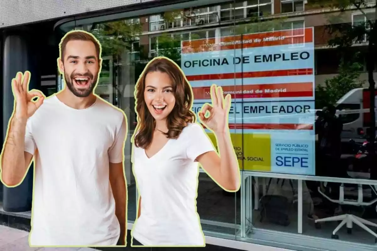 Dos personas sonrientes haciendo el gesto de "OK" frente a una oficina de empleo en Madrid.