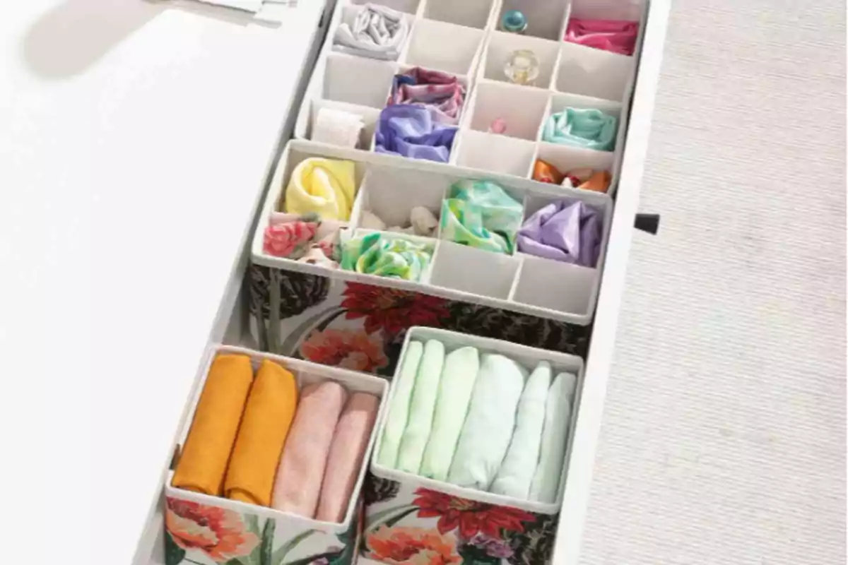 Cajón organizado con separadores de tela estampados y pañuelos de colores doblados cuidadosamente Cajón organizado con separadores de tela estampados y pañuelos de colores doblados cuidadosamente