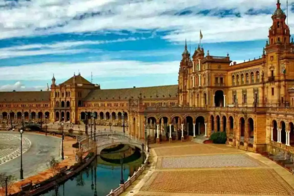 Plaza de España en Sevilla con su arquitectura impresionante y un cielo parcialmente nublado.