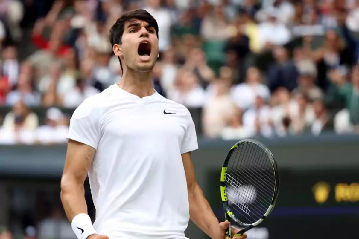 Jugador de tenis celebrando en la cancha con una raqueta en la mano.