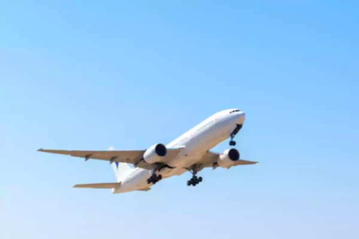 Avión blanco despegando bajo un cielo despejado Avión blanco despegando bajo un cielo despejado