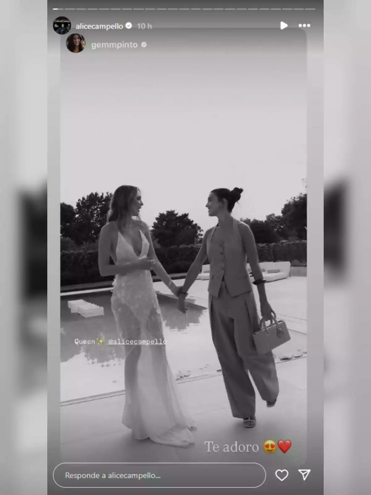 Alice Campello y Gemma Pinto sonríen y se toman de la mano junto a una piscina, una lleva un vestido largo y la otra un conjunto de pantalón y chaleco, ambas parecen felices y elegantes. Alice Campello y Gemma Pinto sonríen y se toman de la mano junto a una piscina, una lleva un vestido largo y la otra un conjunto de pantalón y chaleco, ambas parecen felices y elegantes.
