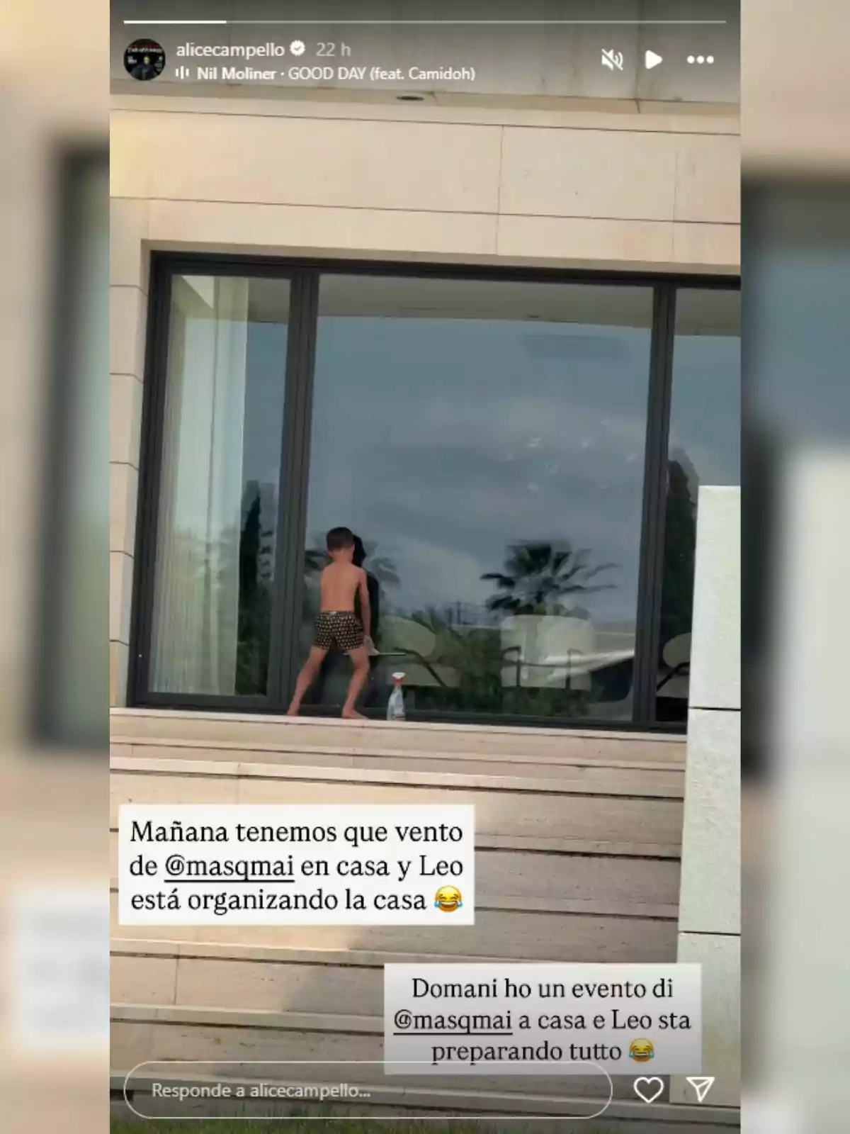 Un niño en ropa de baño está limpiando una ventana grande desde el exterior de una casa moderna mientras hay mensajes en español e italiano sobre un evento y la preparación del lugar Un niño en ropa de baño está limpiando una ventana grande desde el exterior de una casa moderna mientras hay mensajes en español e italiano sobre un evento y la preparación del lugar