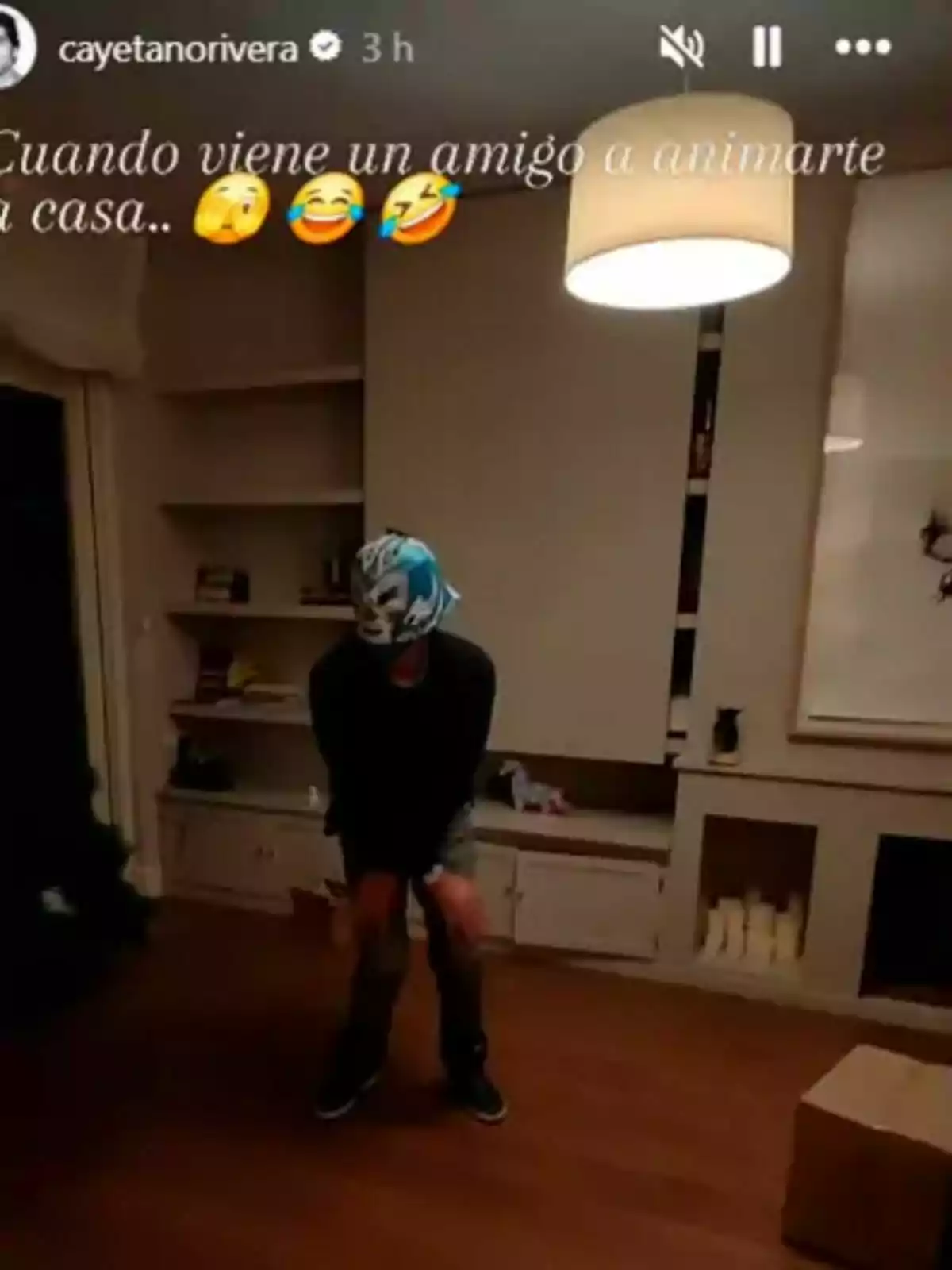 Un hombre con máscara de luchador está en una sala, aparentemente divirtiéndose. Un hombre con máscara de luchador está en una sala, aparentemente divirtiéndose.
