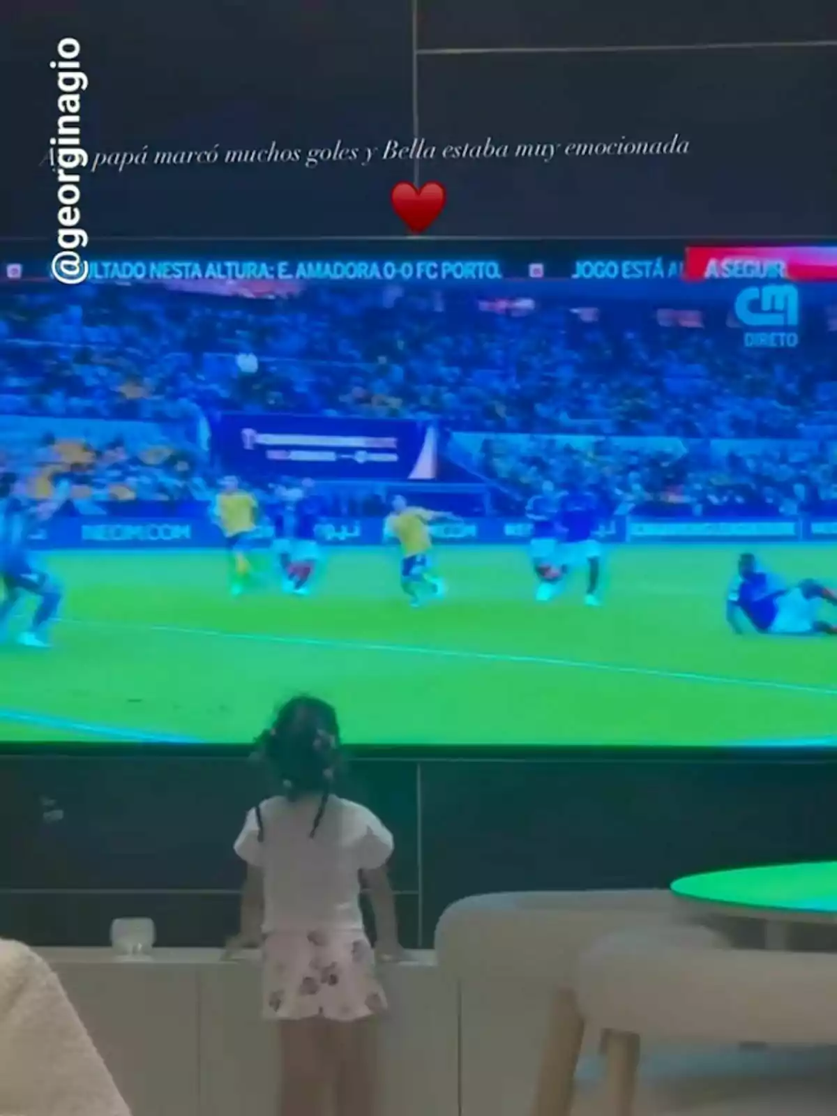 Una niña pequeña observa atentamente un partido de fútbol en la televisión. Una niña pequeña observa atentamente un partido de fútbol en la televisión.