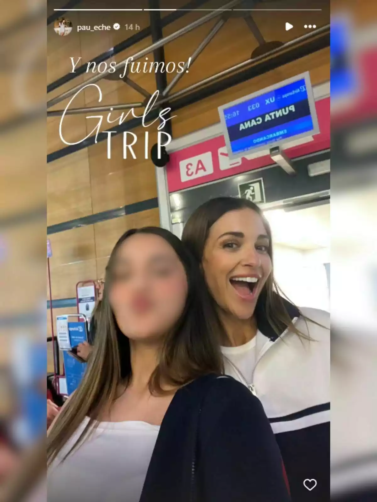 Daniella Bustamante y Paula Echevarría posan sonrientes frente a un cartel de embarque en un aeropuerto, con el texto Daniella Bustamante y Paula Echevarría posan sonrientes frente a un cartel de embarque en un aeropuerto, con el texto