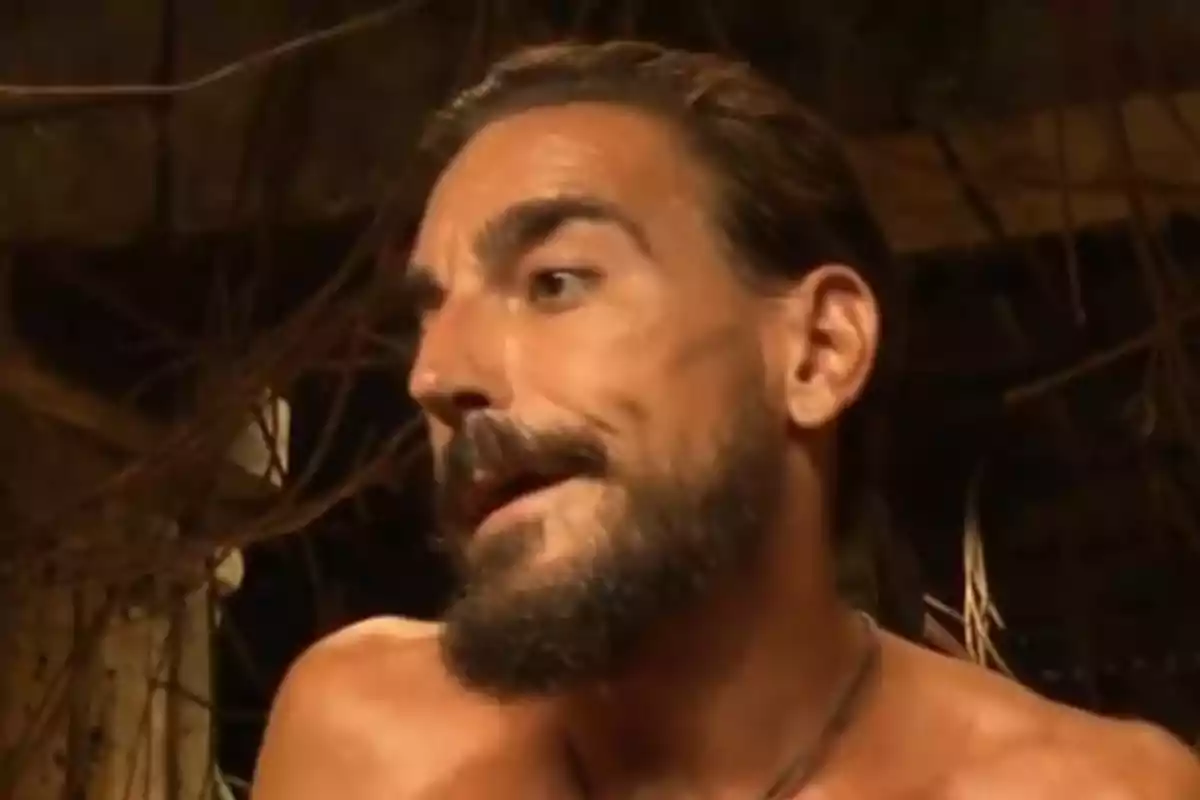 Damián Quintero hablando en un entorno rústico con ramas y madera de fondo. Captura de 'Supervivientes' Damián Quintero hablando en un entorno rústico con ramas y madera de fondo. Captura de 'Supervivientes'