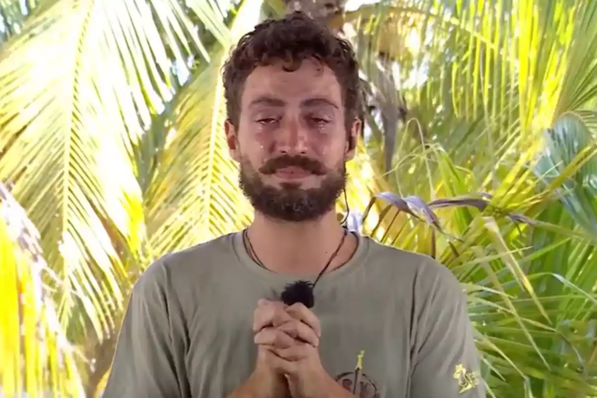 Joshua Velázquez está de pie frente a un fondo de palmeras con una expresión emocional y las manos juntas. Captura de 'Supervivientes' Joshua Velázquez está de pie frente a un fondo de palmeras con una expresión emocional y las manos juntas. Captura de 'Supervivientes'