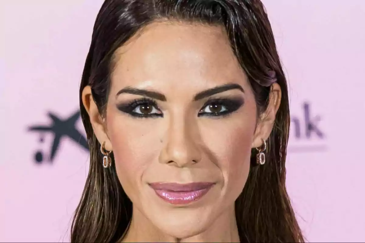 Tamara Gorro con maquillaje oscuro en los ojos y labios rosados, con el cabello oscuro y lacio, usando aretes pequeños, sobre un fondo rosa claro. Tamara Gorro con maquillaje oscuro en los ojos y labios rosados, con el cabello oscuro y lacio, usando aretes pequeños, sobre un fondo rosa claro.