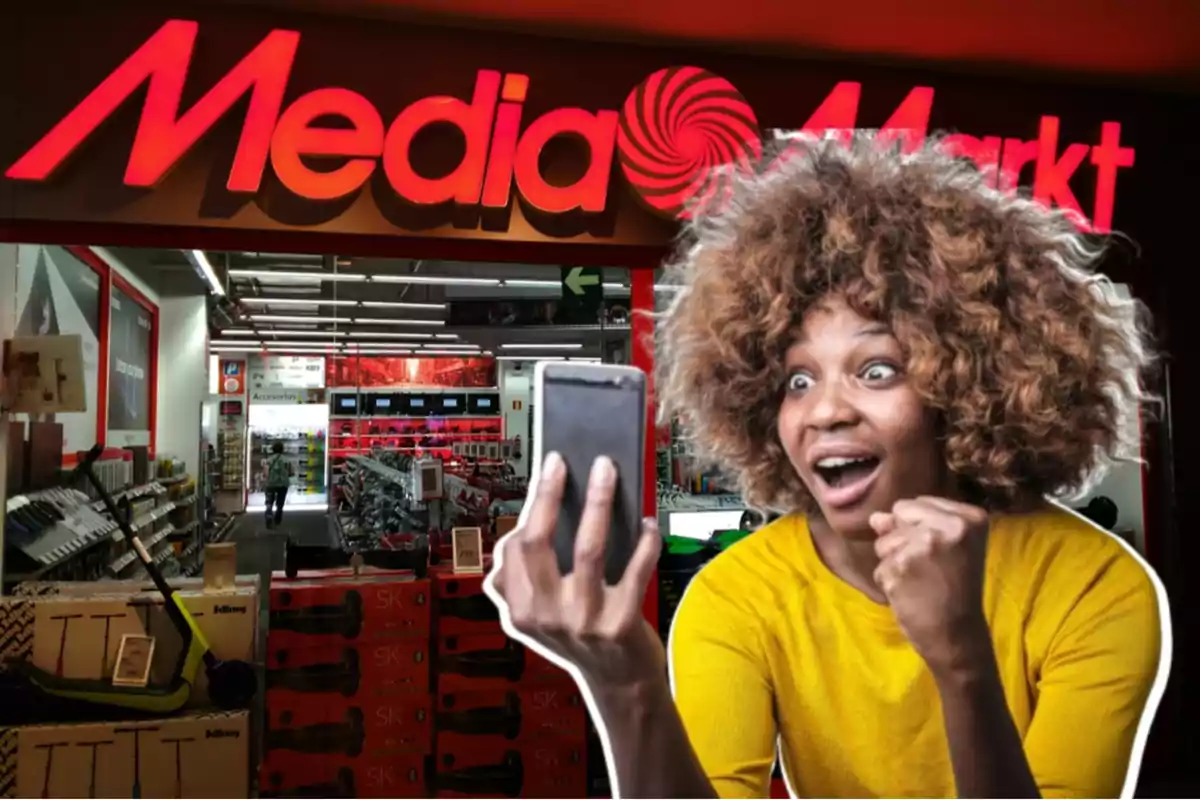 Una mujer emocionada con un teléfono móvil frente a una tienda de Media Markt.