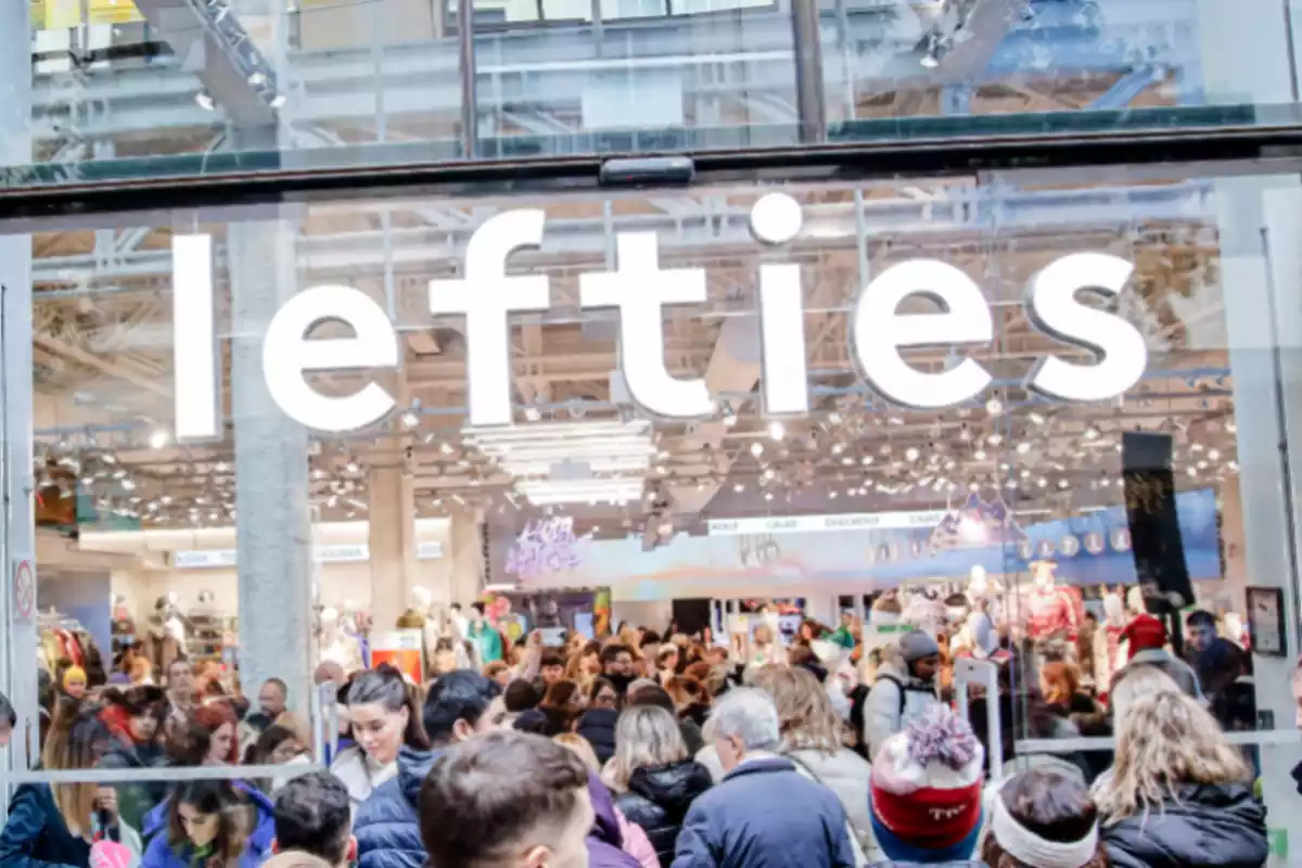 Imagen del exterior de una tienda de Lefties llena de gente comprando, con el letrero encima de la puerta de entrada