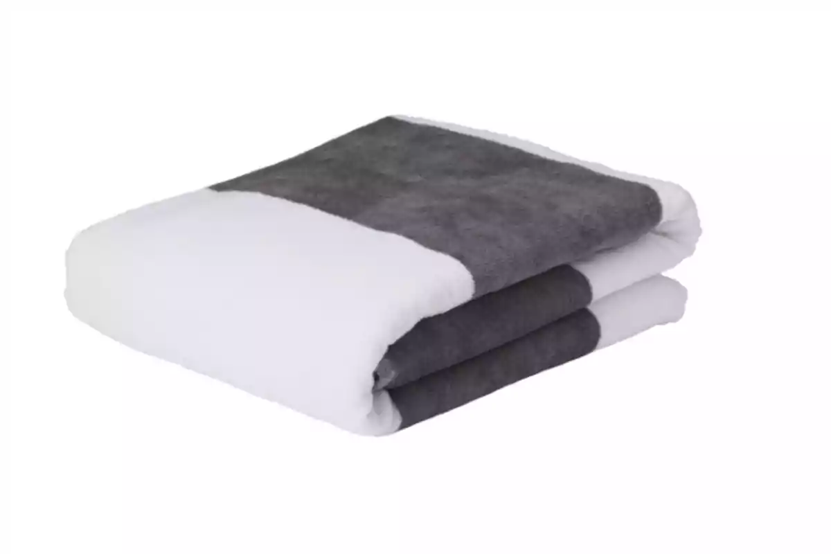 Toalla doblada de color blanco y gris sobre un fondo blanco Toalla doblada de color blanco y gris sobre un fondo blanco