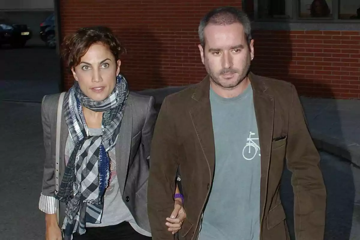 Imagen de Toni Acosta y Jacobo Martos caminando juntos, ella lleva una bufanda a cuadros y él una chaqueta marrón.