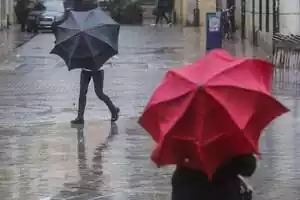 Dos personas con paraguas en medio de la calle durante una tormenta