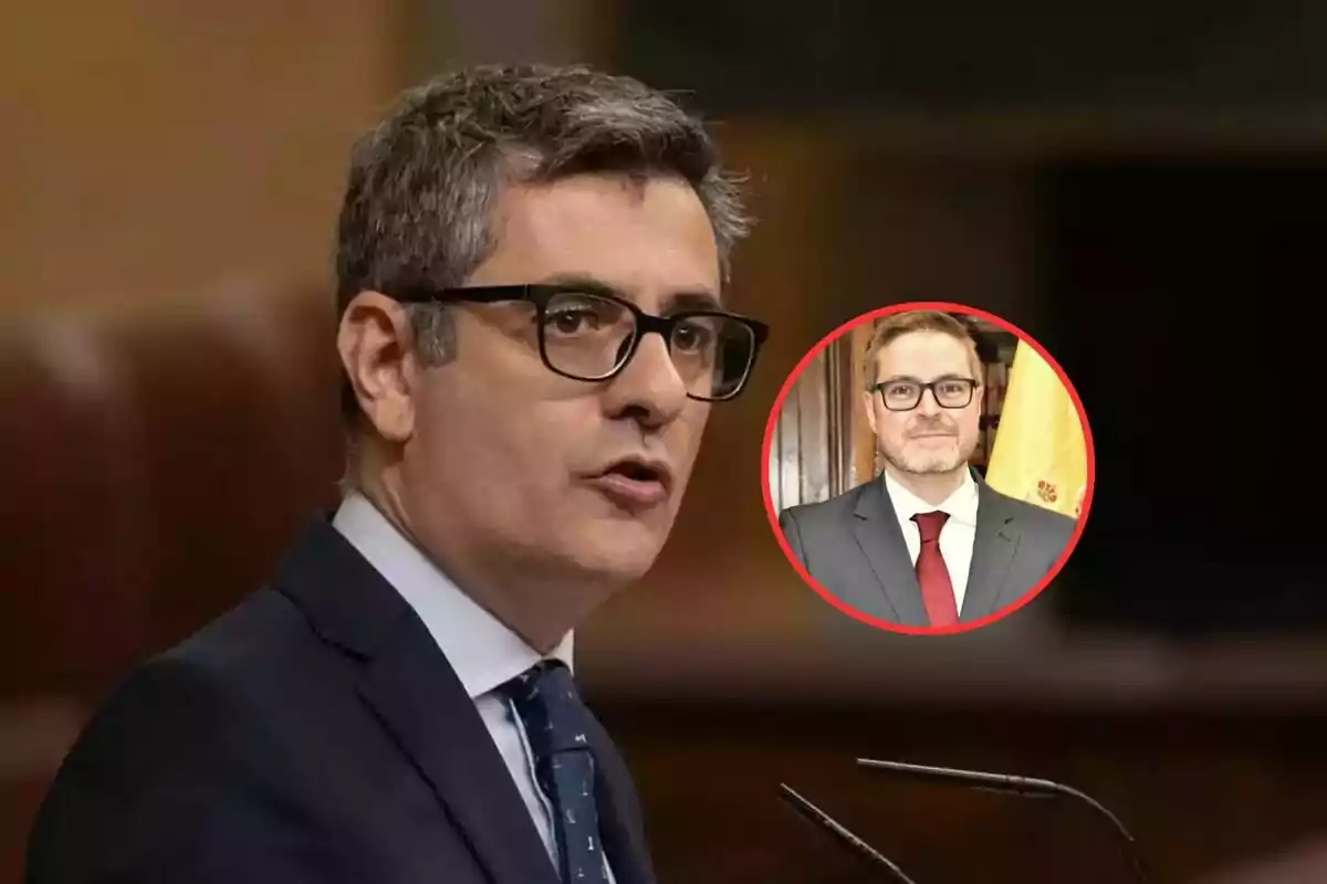 Man with glasses speaking at a podium with an inset showing another person also wearing glasses and a suit.