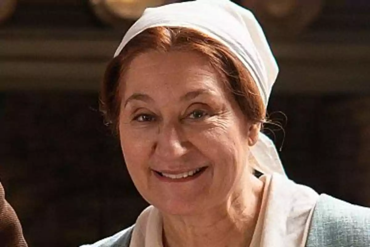 Eva sonriente con un pañuelo blanco en la cabeza. Eva sonriente con un pañuelo blanco en la cabeza.