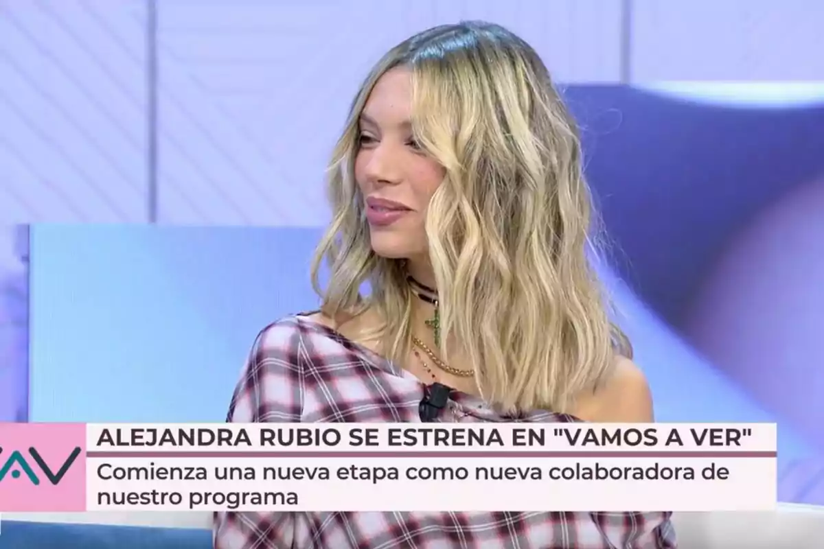 Alejandra Rubio con cabello rubio y ondulado, vestida con una camisa de cuadros, aparece en 'Vamos a Ver' con un texto en pantalla que dice: 