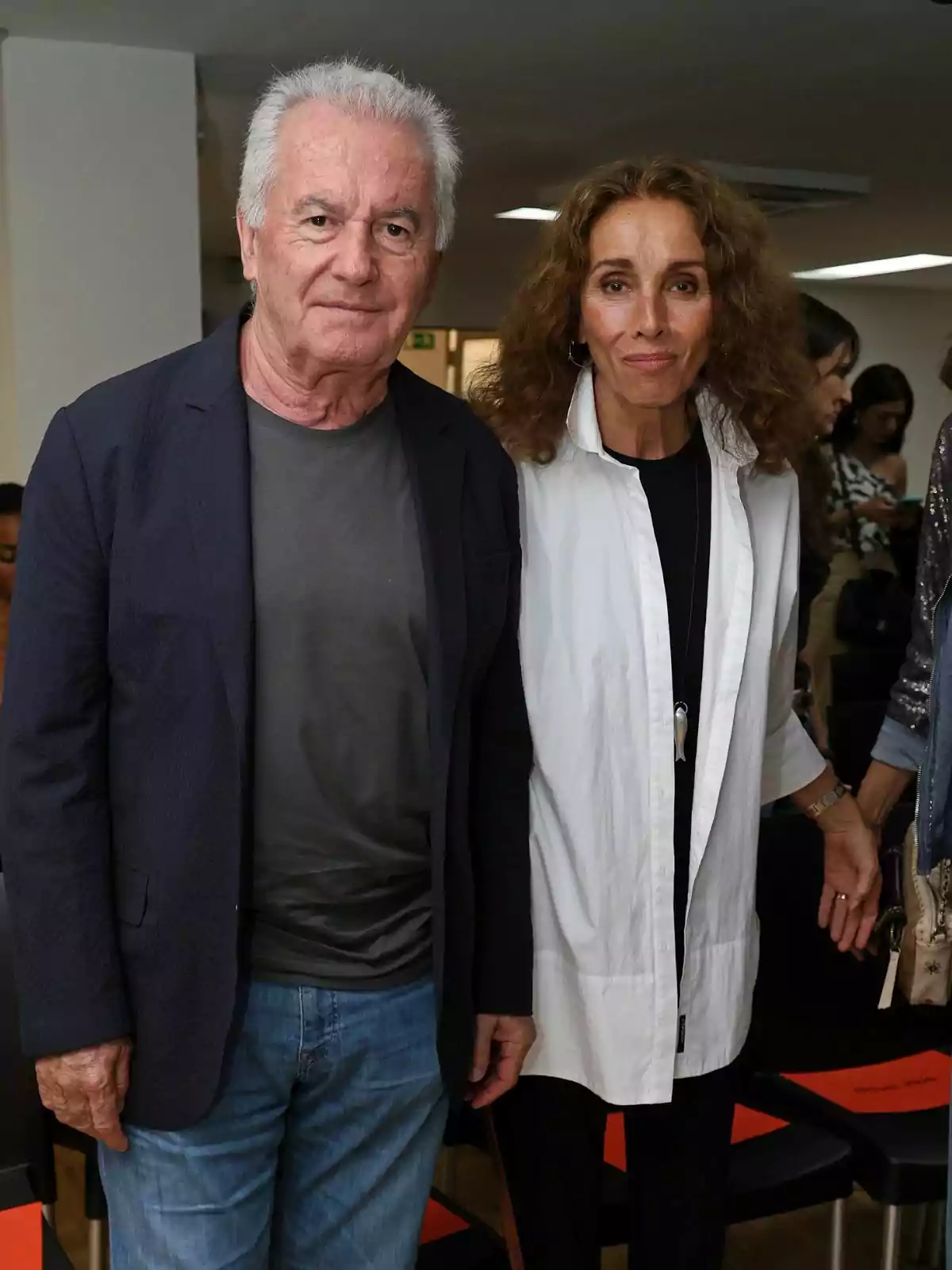 Víctor Manuel y ana Belén posando juntas en un evento, Víctor Manuel lleva una chaqueta oscura y jeans, mientras que Ana Belén viste una camisa blanca y pantalones oscuros. Víctor Manuel y ana Belén posando juntas en un evento, Víctor Manuel lleva una chaqueta oscura y jeans, mientras que Ana Belén viste una camisa blanca y pantalones oscuros.