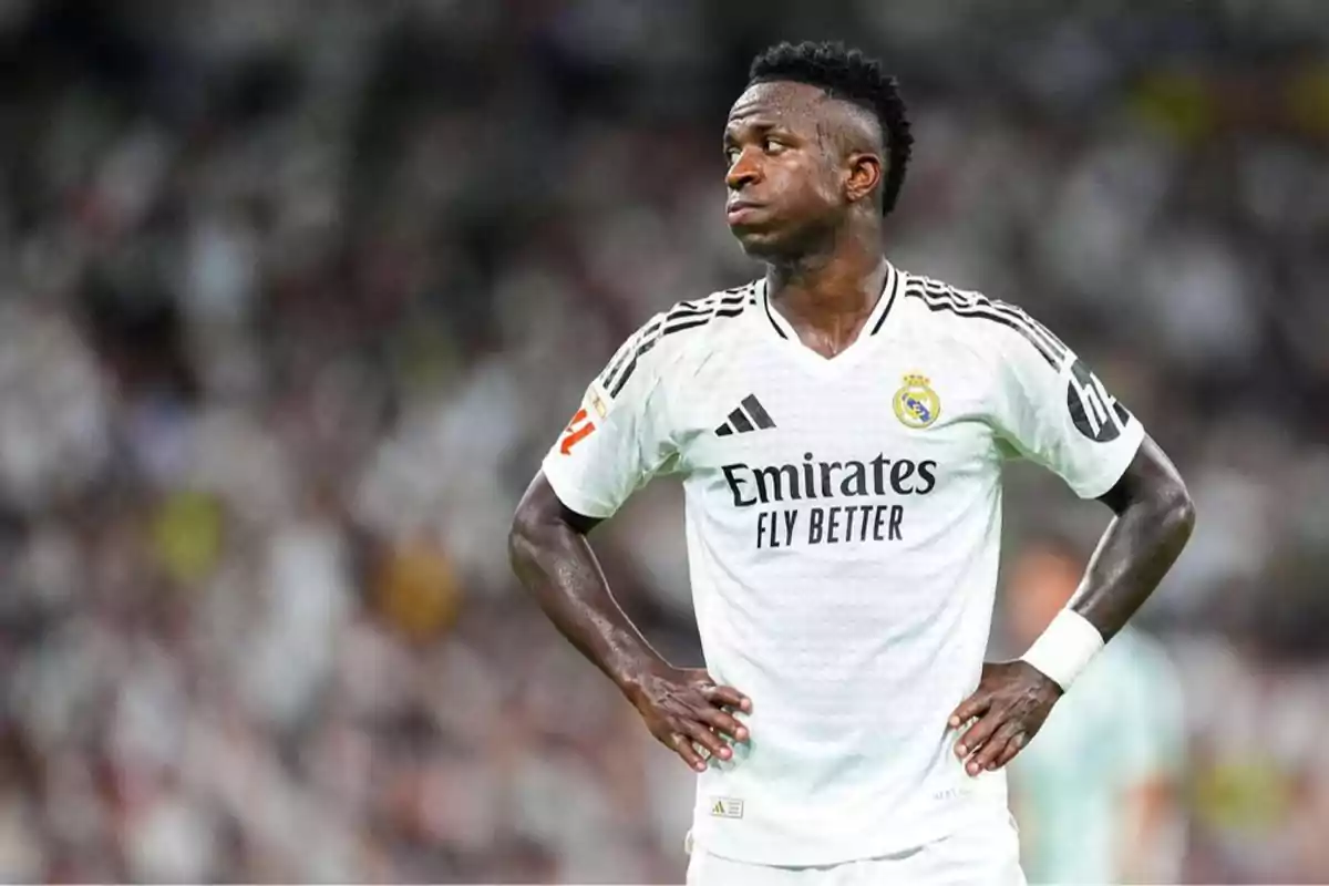 Jugador de fútbol con uniforme blanco del Real Madrid en el campo de juego.