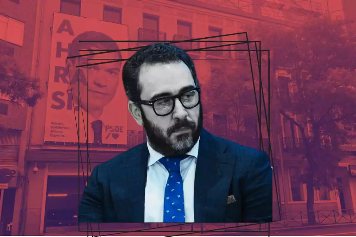 Un hombre con barba y gafas en un traje azul con una corbata azul, sobre un fondo rojo con un cartel político.