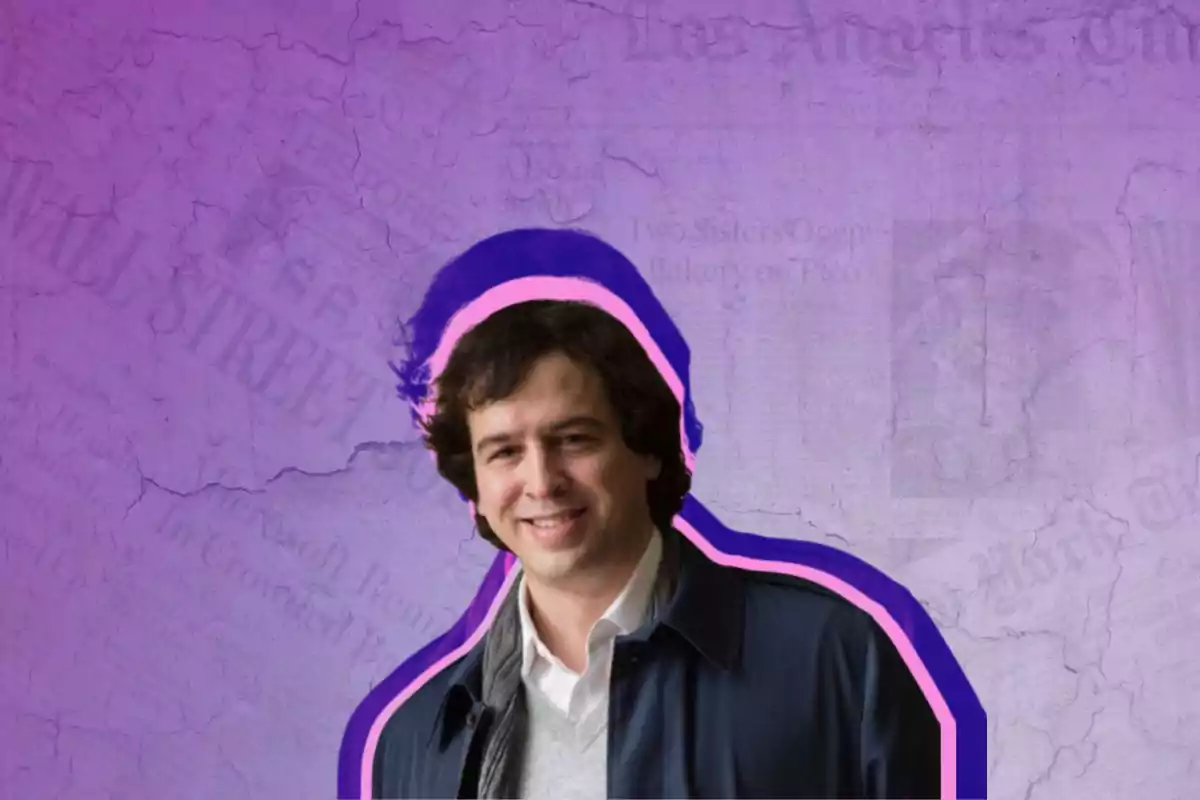 Un hombre sonriente con cabello oscuro y chaqueta azul, con un fondo morado y detalles de periódicos.