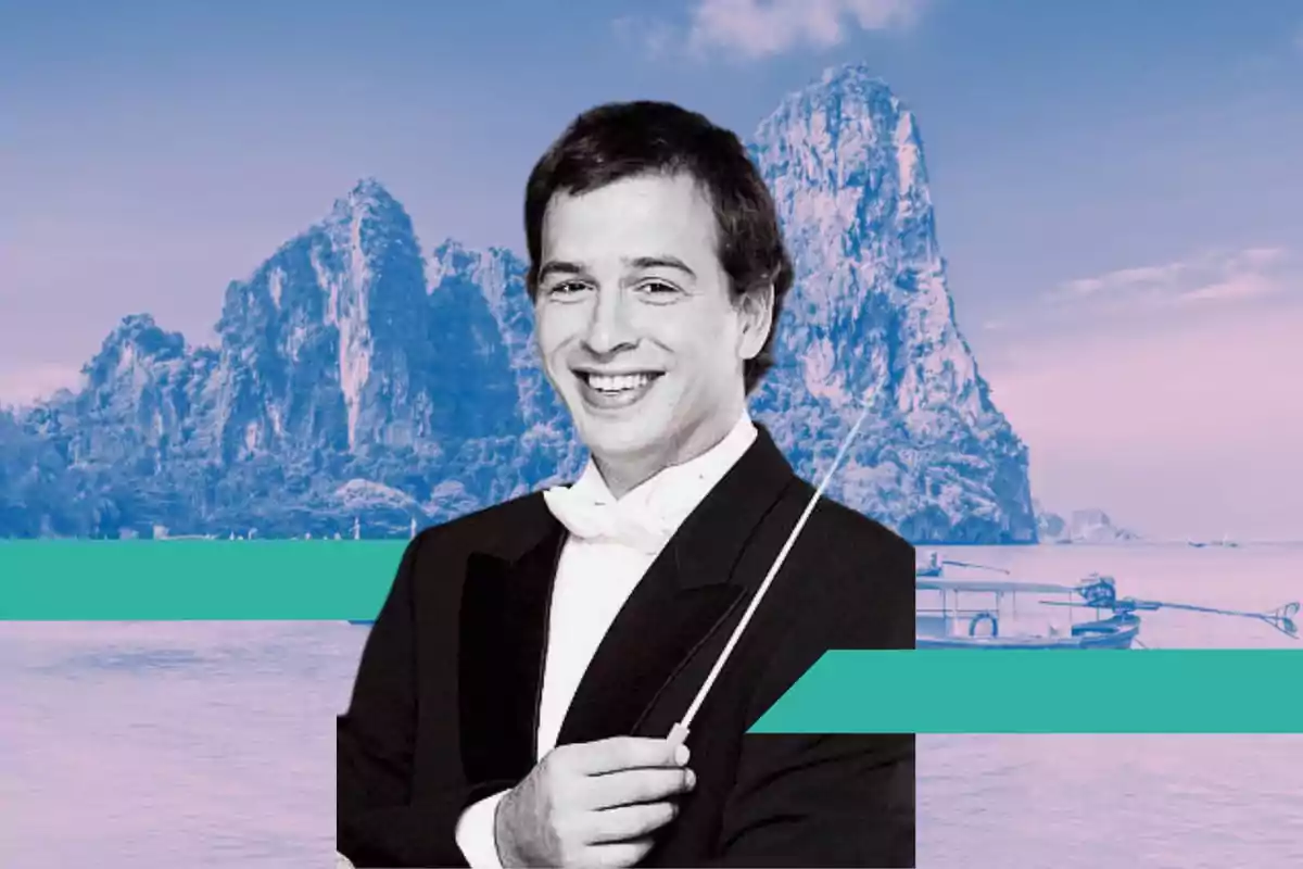 Un director de orquesta sonriente con un fondo de montañas y un lago.