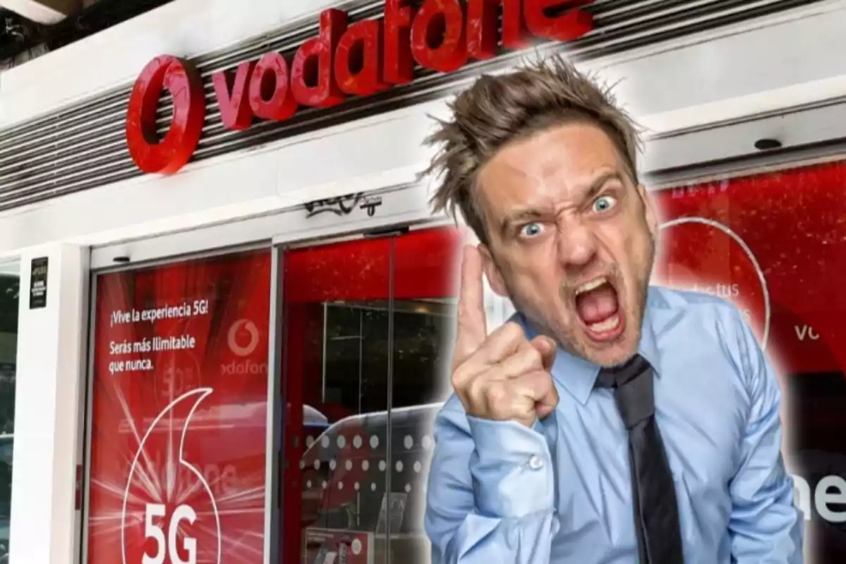 A man with an angry expression and pointing his finger in front of a Vodafone store.