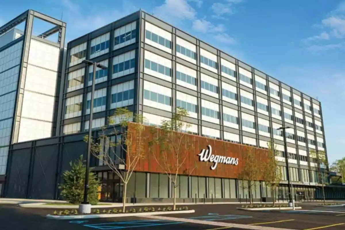 Modern multi-story building with the Wegmans sign on the facade and an empty parking lot in front Modern multi-story building with the Wegmans sign on the facade and an empty parking lot in front