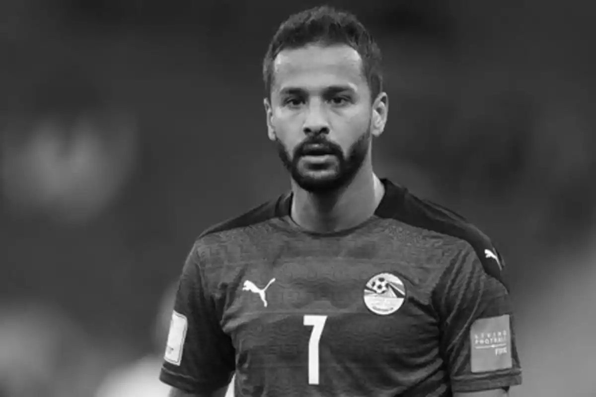 Un jugador de fútbol con barba y cabello corto, vistiendo una camiseta con el número 7 y el logo de Puma, en blanco y negro.