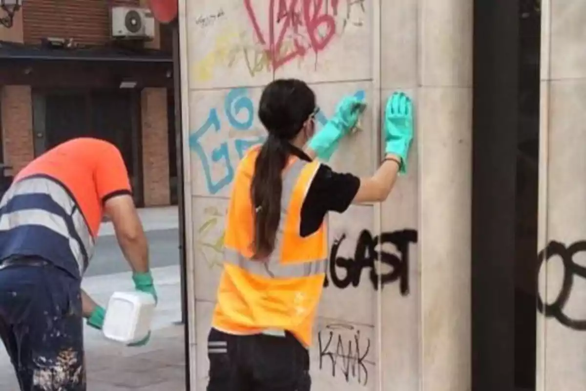 Operarios de Castellón limpiando grafitis de una pared en una calle