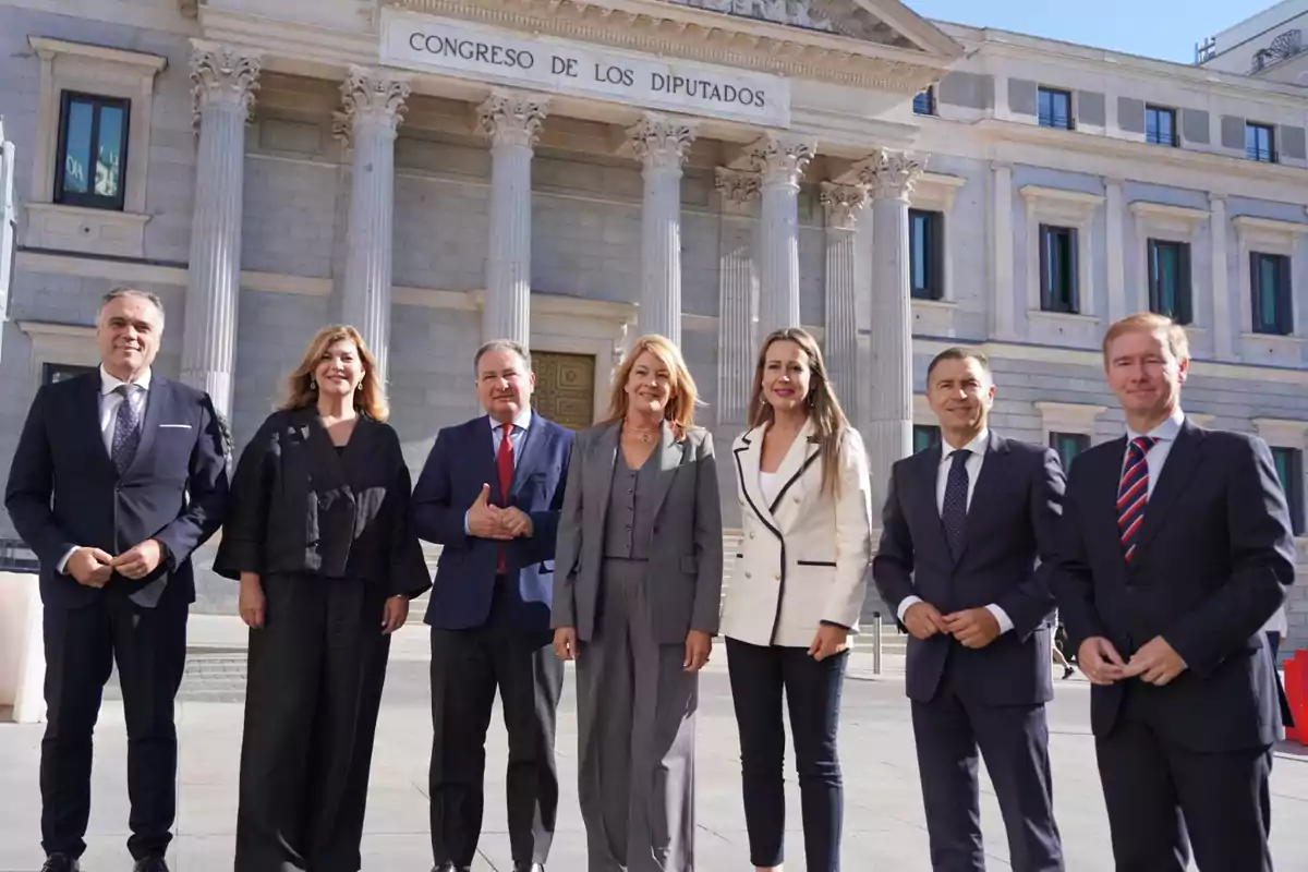 Un grupo de personas posando frente al edificio del Congreso de los Diputados.