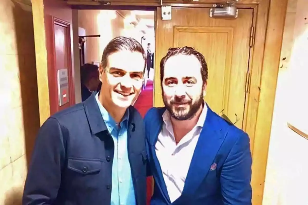 Dos hombres posan juntos en un pasillo iluminado. Dos hombres posan juntos en un pasillo iluminado.