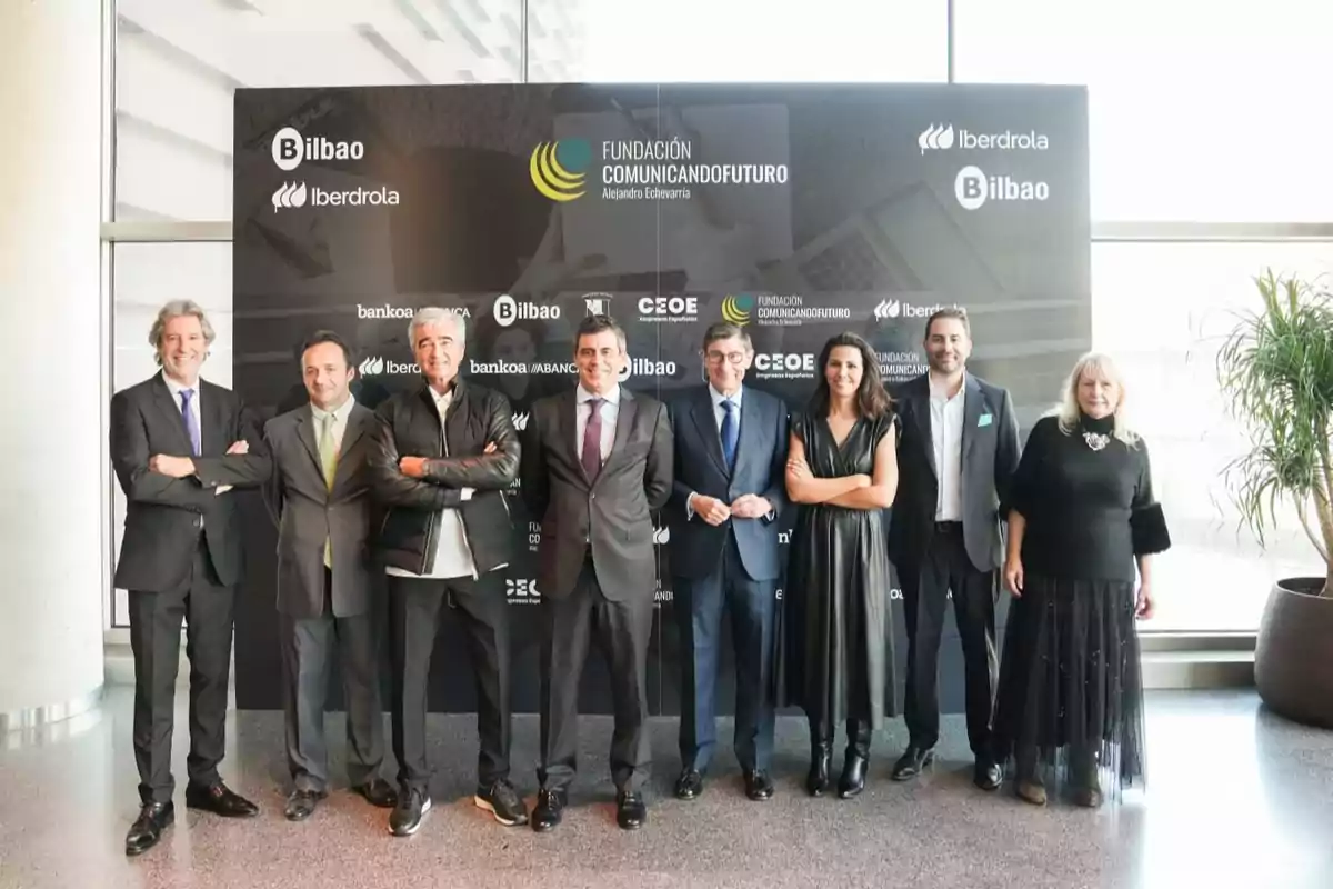 Un grupo de personas posando frente a un cartel de la Fundación Comunicando Futuro en un evento en Bilbao.