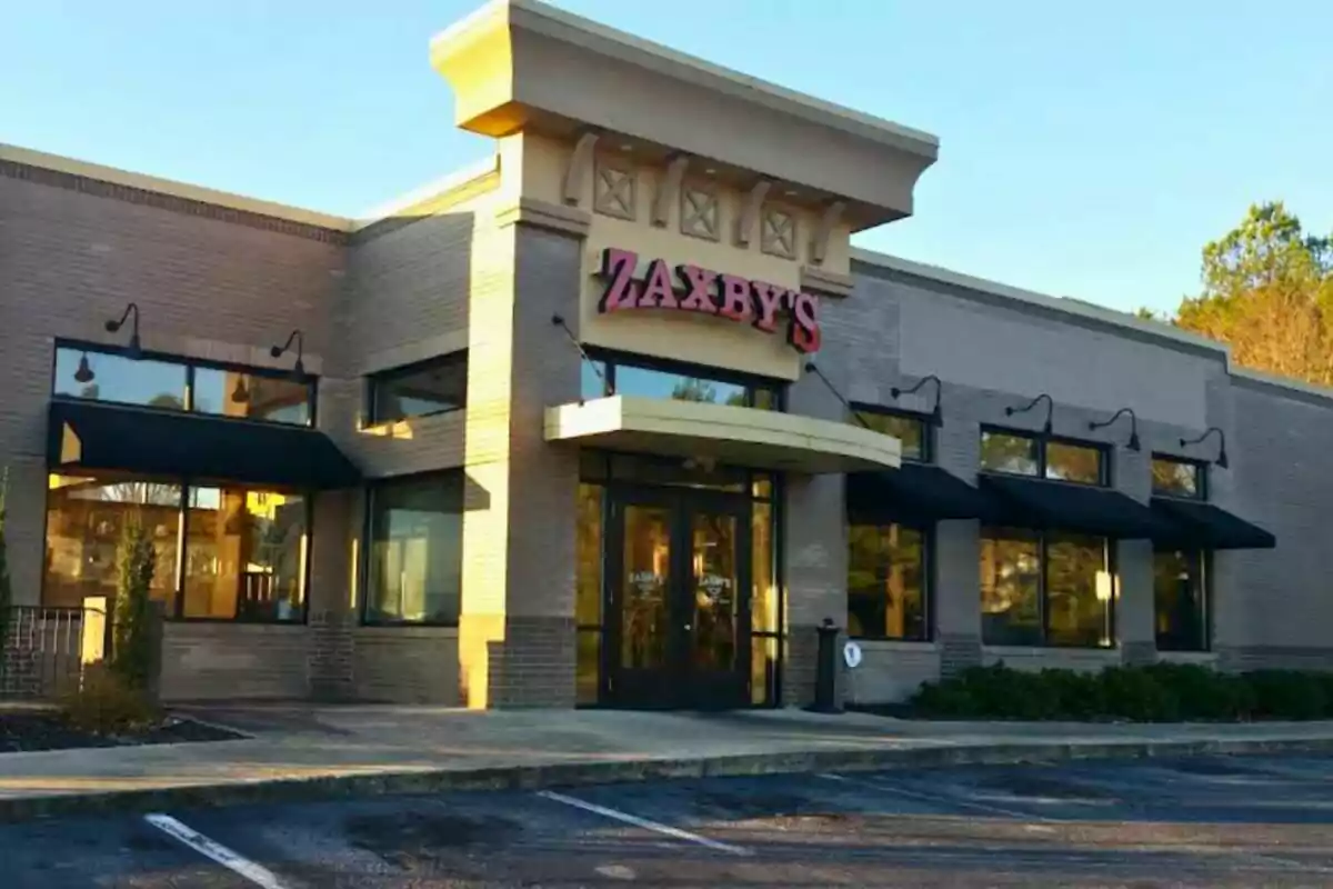 Facade of a Zaxby's restaurant with large windows and black awnings on a sunny day Facade of a Zaxby's restaurant with large windows and black awnings on a sunny day