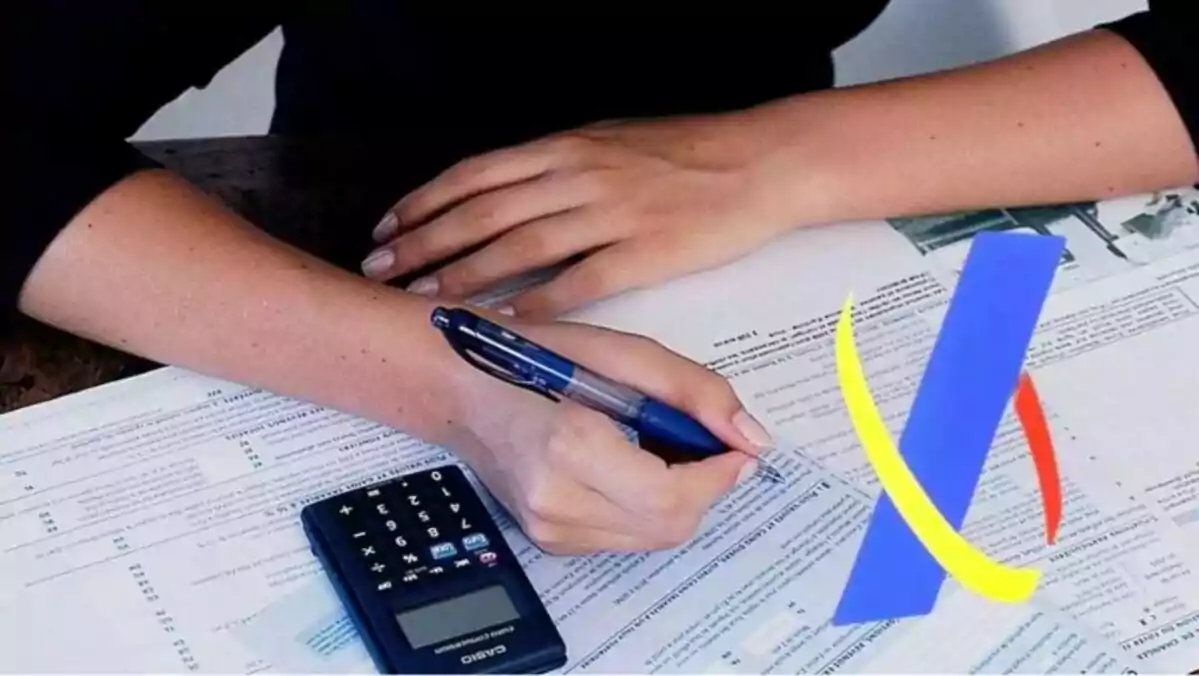 Una persona con un bolígrafo en la mano rellenando papeles