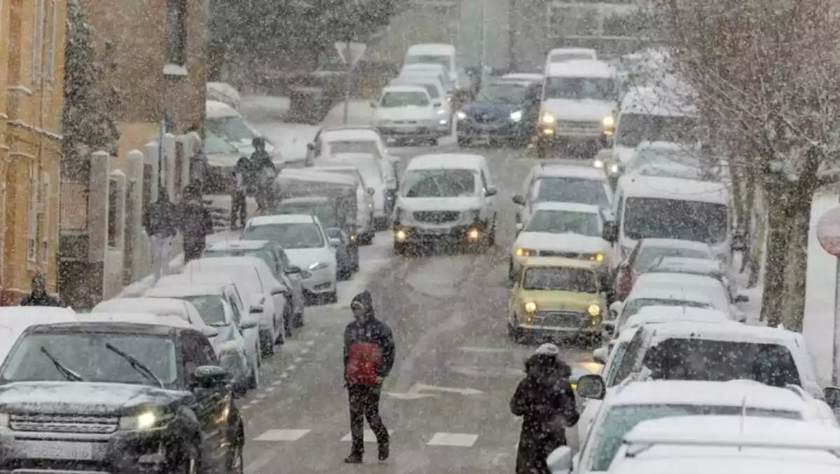 Carretera de Soria con gente abrigada y nieve cayendo